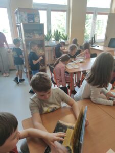 Dzieci zwiedzają budynek szkoły - wizyta w bibliotece.